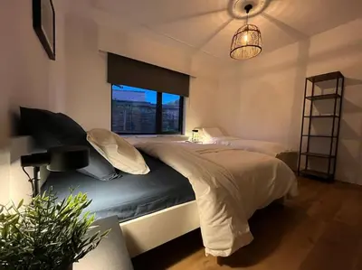 a bedroom with a large bed and a window at Boldermountain Guesthouse in Heusden - Zolder