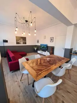 a living room with a wooden table and a red couch at Duplex dans le centre d'Heusy in Verviers