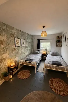 a bedroom with two beds and a window at Duplex dans le centre d'Heusy in Verviers