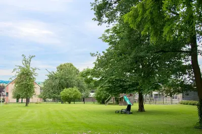 a person sitting on a bench in a park at B&B De Oude Winning in Riemst