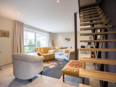 a living room with a spiral staircase and a living room at Achter de Hegge in Riemst