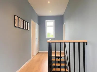 a staircase in a house with blue walls and a window at Woonhuys in Riemst