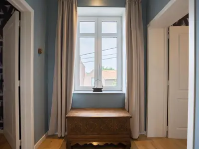 a window in a hallway with a bench under it at Woonhuys in Riemst