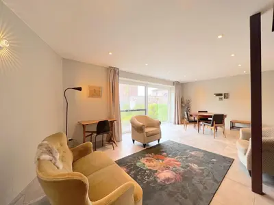 a living room with a couch and a dining room at t Bakhuys in Riemst