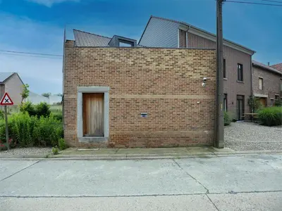 a brick wall with a door on the side of a house at t Bakhuys in Riemst