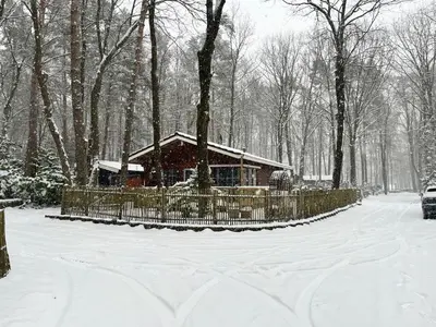 a house in the snow with a fence at Vakantiechalet voor 4 plus 2 met sauna in Lanaken