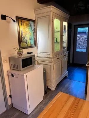 a kitchen with a microwave and a large cabinet at Vakantiechalet voor 4 plus 2 met sauna in Lanaken