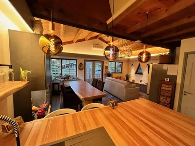 a kitchen and dining room with a large wooden table at Vakantiechalet voor 4 plus 2 met sauna in Lanaken