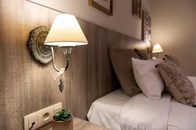 a hotel room with a bed and a lamp at Hôtel de la Tour in Melen