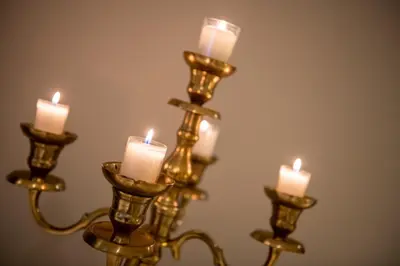 a candle holder with three lit candles on it at Hôtel de la Tour in Melen