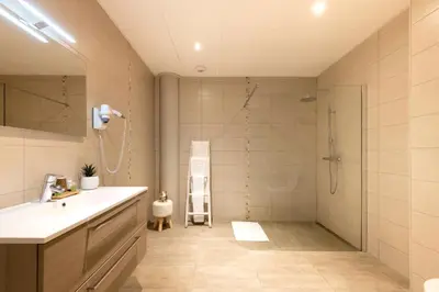 a bathroom with a shower and a sink and a mirror at Hôtel de la Tour in Melen