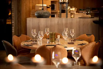a table with wine glasses on it in a restaurant at Hôtel de la Tour in Melen