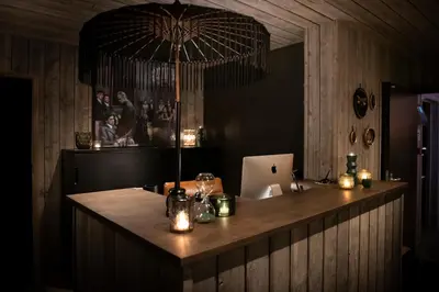 a bar with a table with candles and an umbrella at Hôtel de la Tour in Melen