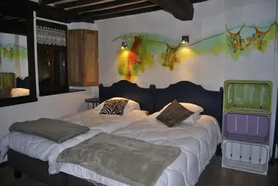 a bedroom with two beds and a painting on the wall at Le Chat Roi - Charneux in Herve