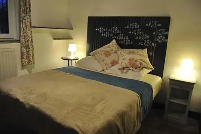 a bedroom with a large bed with two lamps at Le Chat Roi - Charneux in Herve