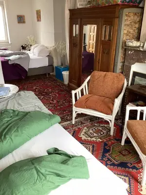 a room with two beds and a chair and a table at Au 81 in Liège