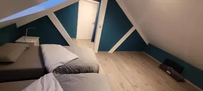a bedroom with two beds in a room with blue walls at Gîte de Trasenster in Trooz