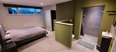 a bedroom with a bed and a bathroom with a shower at Gîte de Trasenster in Trooz
