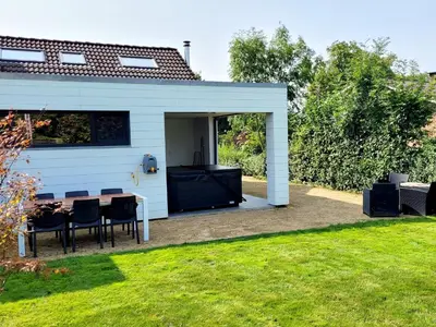 a white shed with a table and chairs in a yard at Gîte de Trasenster in Trooz