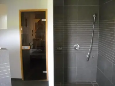 a bathroom with a shower with a glass door at À la Belle Vue in Limbourg
