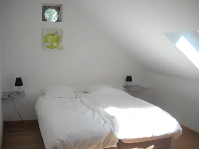 a white bed in a white bedroom with a window at À la Belle Vue in Limbourg