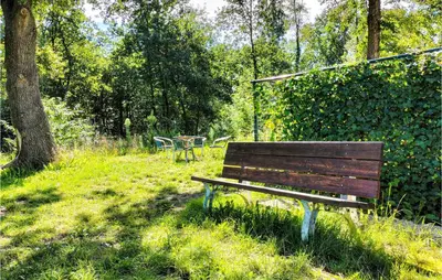a wooden bench sitting in a park next to a hedge at Pet Friendly Home In As With Wifi in As