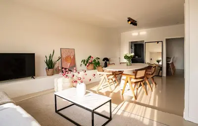 a living room with a table and a couch at Maas Suites - The River House with private sauna in Lanaken