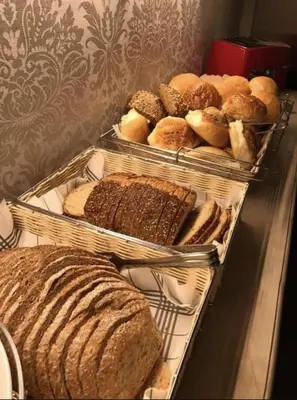 two baskets filled with different types of bread on a shelf at Boutique Hotel Huys van Steyns in Tongeren