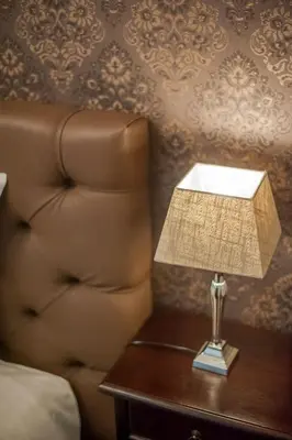 a lamp on a table next to a chair at Boutique Hotel Huys van Steyns in Tongeren
