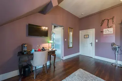 a home office with a desk and a table at Boutique Hotel Huys van Steyns in Tongeren