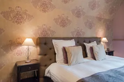 a bed with white sheets and pillows in a bedroom at Boutique Hotel Huys van Steyns in Tongeren