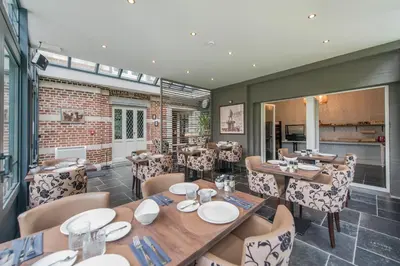 a dining room with tables and chairs and a brick wall at Boutique Hotel Huys van Steyns in Tongeren