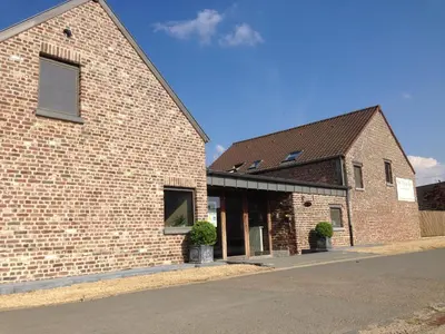 a brick building with two potted plants in front of it at Luxe hoeve voor groepen tot 26 personen in Borgloon in Borgloon
