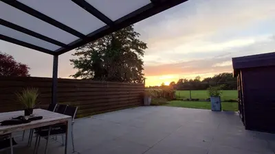 a patio with a table and chairs and a fence at Tuinappartement van 175m² en 4 slaapkamers in Hasselt