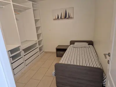 a bedroom with a bed and a closet at Tuinappartement van 175m² en 4 slaapkamers in Hasselt