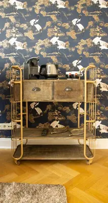 a shelf in a room with a wallpaper with white birds at B&B Huis Spaas in Pelt