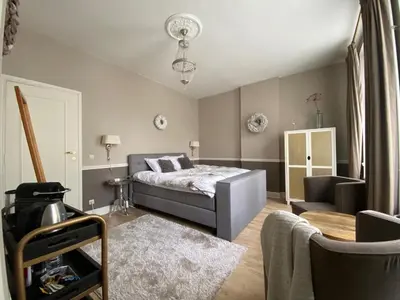 a bedroom with a bed and a couch and a chair at B&B Huis Spaas in Pelt