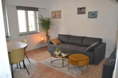 a living room with a couch and a table at De zwarte deur in Genk