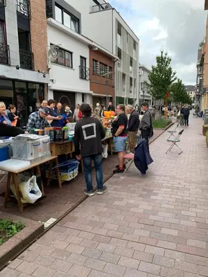 a group of people standing around a market on a street at De zwarte deur in Genk