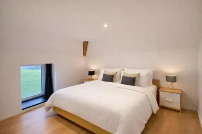 a bedroom with a large white bed and a window at Spa-Francorchamps - Jahlay - Maison 6p de caractère - Famille - Ardennes - Nature in Jalhay