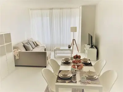 a white living room with a table and a couch at COCONUT MILK in Liège
