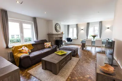 a living room with a couch and a table at Aan de bosrand in Oudsbergen