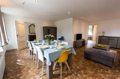 a dining room with a blue table and chairs at Aan de bosrand in Oudsbergen