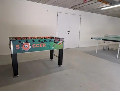 a ping pong table with a sign on it in a room at Aan de bosrand in Oudsbergen