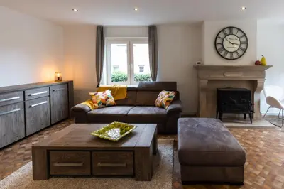a living room with a couch and a fireplace at Aan de bosrand in Oudsbergen