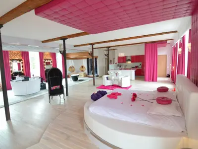 a bedroom with a large white bed with red flowers on it at Cozy Stay with Pool & Nature in Ensival