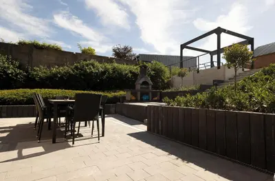a patio with a table and chairs and a fence at Vakantiewoning Het Kwartelnest Mettekoven (Heers) in Heers