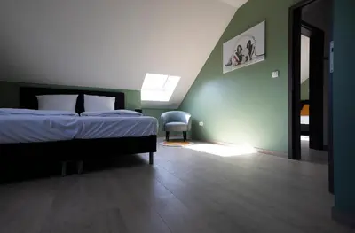 a bedroom with a bed and a chair in it at Vakantiewoning Het Kwartelnest Mettekoven (Heers) in Heers