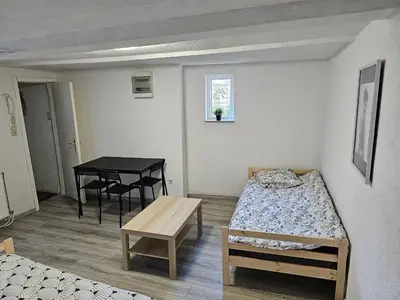 a small room with two beds and a table at Logment Outremeuse 1D in Liège