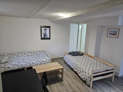 a small room with two beds and a table at Logment Outremeuse 1D in Liège